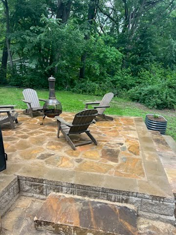 Natural flagstone patio with Adirondack chairs and chiminea