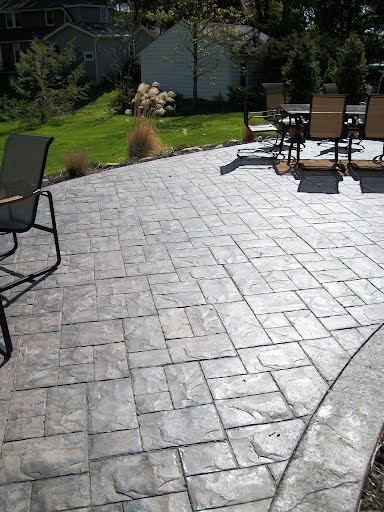 Stamped paver patio with dining set in a manicured backyard